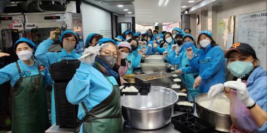 임영웅 팬클럽 영웅시대밴드(나눔모임) 회원들이 지난 9일 서울 용산구 후암로 천주교서울대교구 가톨릭사랑평화의 집에서 도시락 봉사를 하며 기념 사진을 찍고 있다, <나눔모임 제공>